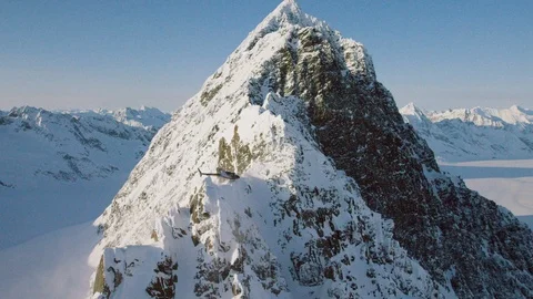Helicopter hovering above a snowy mountain ridge Stock Footage 113254352