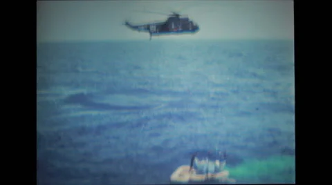 Helicopter hovering close to spacecraft in water and divers opening the hatch Stock Footage 37596738