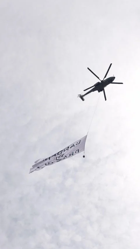 Helicopter hovers above cloudy sky with a flag in Mexico Stock Footage 344336003