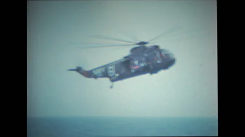 Helicopter hovers close to spacecraft and pararescue divers swim over Stock-Footage 37596572