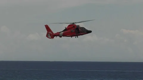 Helicopter hovers over swimmer Stock Footage 77600507