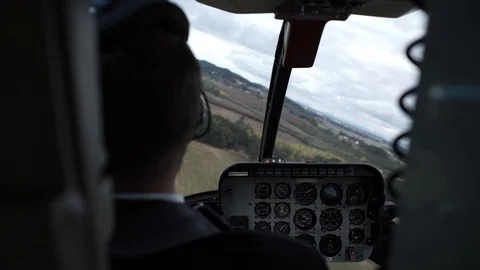 Helicopter interior behind pilot looking out at countryside scenery 스톡 동영상 104456781