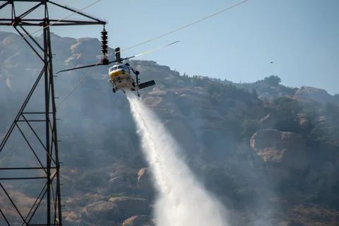 A helicopter from the LACFD performs a water drop and observation during a br Foto stock