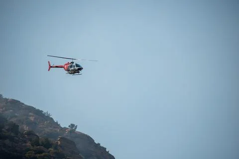 A helicopter from the LAFD performs a water drop and observation during a bru Foto stock
