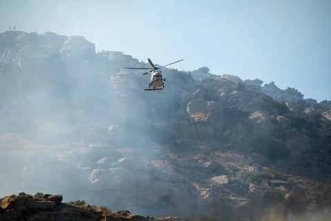 A helicopter from the LAFD performs a water drop and observation during a bru Foto stock