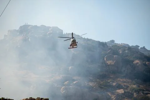 A helicopter from the LAFD performs a water drop and observation during a bru Foto stock