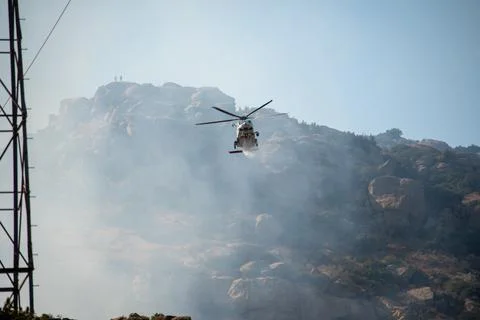 A helicopter from the LAFD performs a water drop and observation during a bru Foto stock