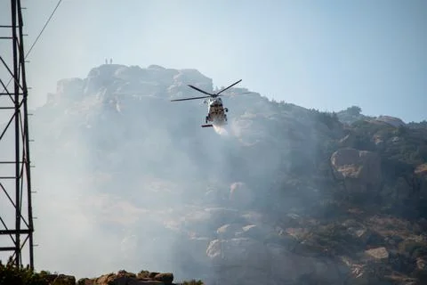 A helicopter from the LAFD performs a water drop and observation during a bru Foto stock