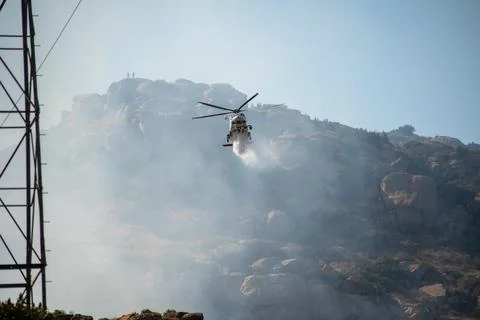 A helicopter from the LAFD performs a water drop and observation during a bru Foto stock