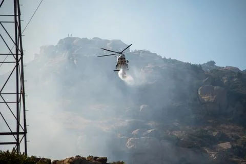 A helicopter from the LAFD performs a water drop and observation during a bru Stock Photos
