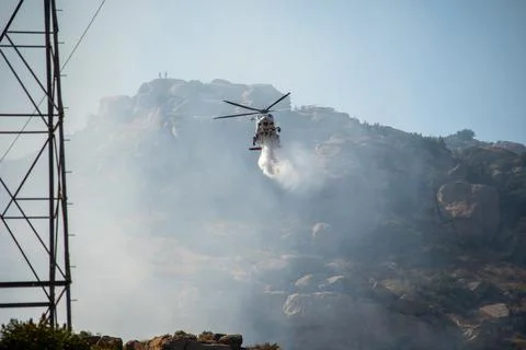 A helicopter from the LAFD performs a water drop and observation during a bru Stock Photos