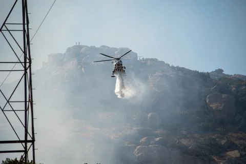 A helicopter from the LAFD performs a water drop and observation during a bru Foto stock