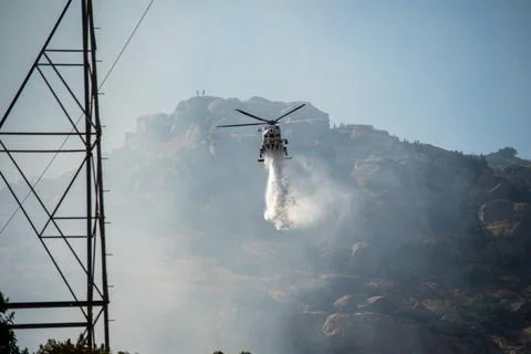 A helicopter from the LAFD performs a water drop and observation during a bru Foto stock