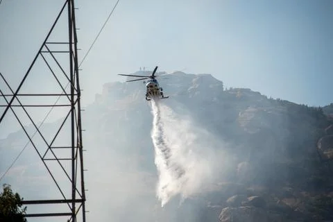 A helicopter from the LAFD performs a water drop and observation during a bru Foto stock