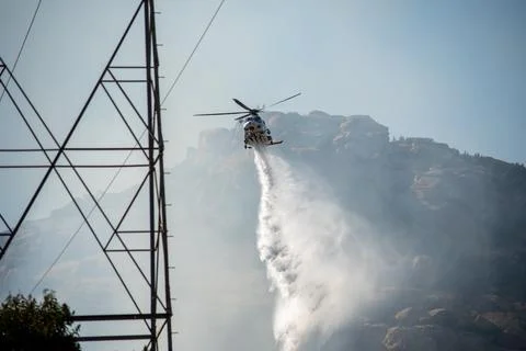 A helicopter from the LAFD performs a water drop and observation during a bru Stock Photos