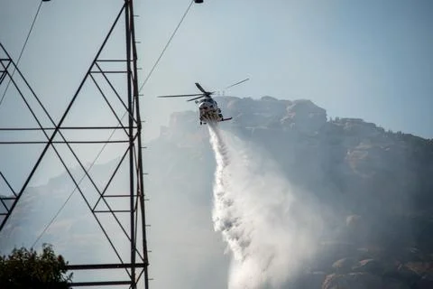 A helicopter from the LAFD performs a water drop and observation during a bru Foto stock