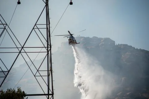 A helicopter from the LAFD performs a water drop and observation during a bru Foto stock