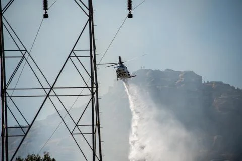 A helicopter from the LAFD performs a water drop and observation during a bru Foto stock