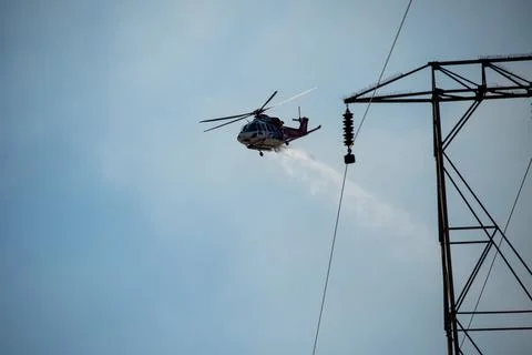 A helicopter from the LAFD performs a water drop and observation during a bru Stock Photos
