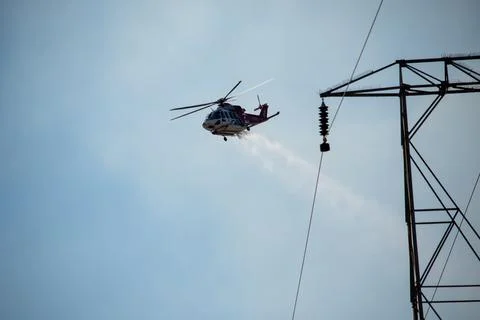 A helicopter from the LAFD performs a water drop and observation during a bru Foto stock
