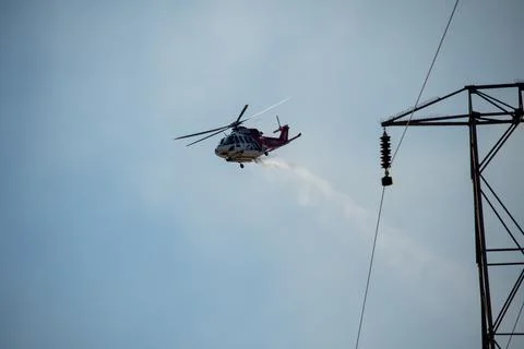 A helicopter from the LAFD performs a water drop and observation during a bru Foto stock