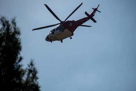 A helicopter from the LAFD performs a water drop on burning brush through smo Stock Photos