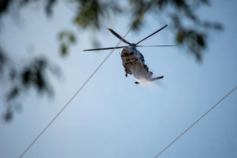 A helicopter from the LAFD performs a water drop and observation during a bru Foto stock