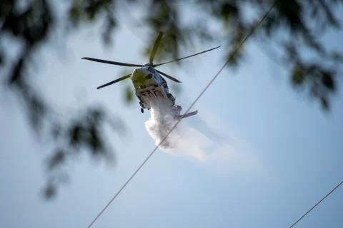 A helicopter from the LAFD performs a water drop and observation during a bru Stock Photos