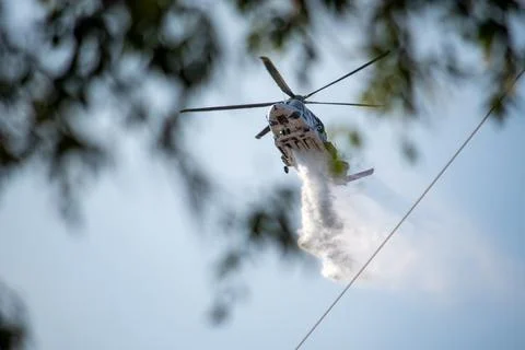 A helicopter from the LAFD performs a water drop and observation during a bru Stock Photos