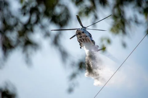 A helicopter from the LAFD performs a water drop and observation during a bru Foto stock