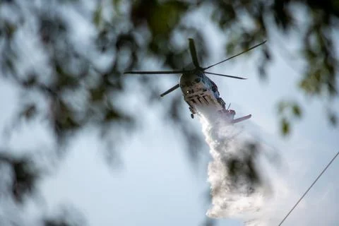 A helicopter from the LAFD performs a water drop and observation during a bru Foto stock