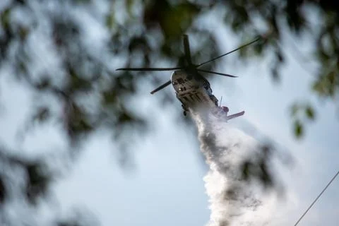 A helicopter from the LAFD performs a water drop and observation during a bru Foto stock