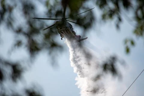 A helicopter from the LAFD performs a water drop and observation during a bru Foto stock