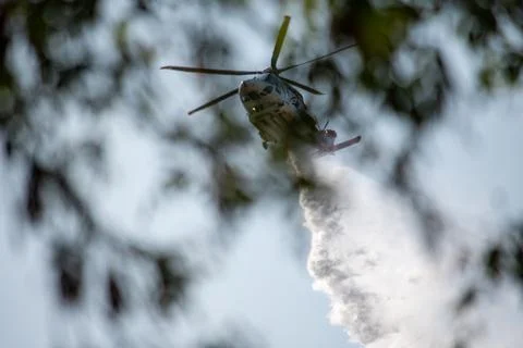 A helicopter from the LAFD performs a water drop and observation during a bru Foto stock