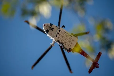 A helicopter from the LAFD performs a water drop and observation during a bru Foto stock