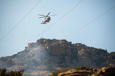 A helicopter from the LAFD performs a water drop and observation during a bru Foto stock