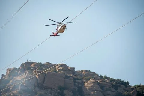A helicopter from the LAFD performs a water drop and observation during a bru Stock Photos