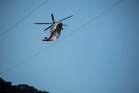 A helicopter from the LAFD performs a water drop and observation during a bru Stock Photos