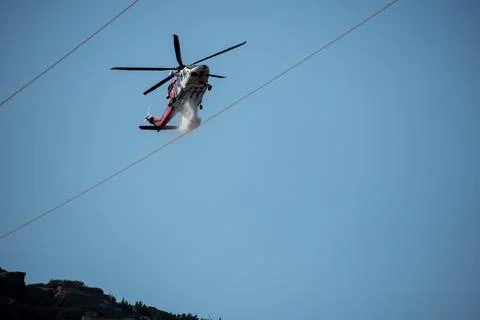 A helicopter from the LAFD performs a water drop and observation during a bru Foto stock