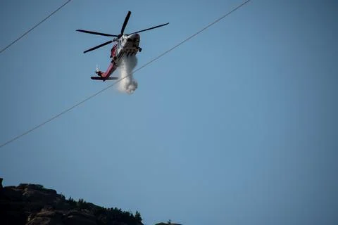 A helicopter from the LAFD performs a water drop and observation during a bru Foto stock