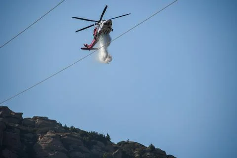 A helicopter from the LAFD performs a water drop and observation during a bru Stock Photos