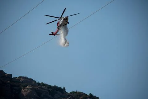 A helicopter from the LAFD performs a water drop and observation during a bru Foto stock
