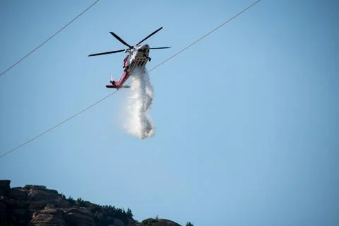 A helicopter from the LAFD performs a water drop and observation during a bru Foto stock