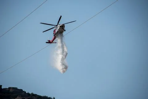 A helicopter from the LAFD performs a water drop and observation during a bru Stock Photos