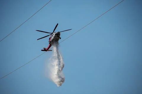 A helicopter from the LAFD performs a water drop and observation during a bru Foto stock