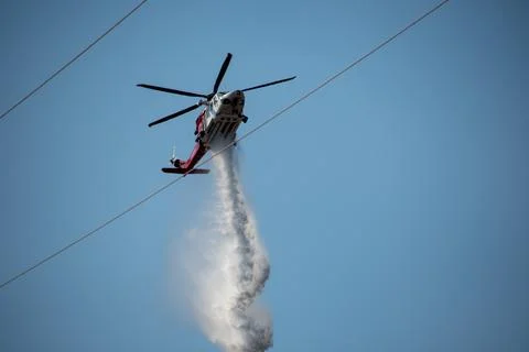 A helicopter from the LAFD performs a water drop and observation during a bru Stock Photos