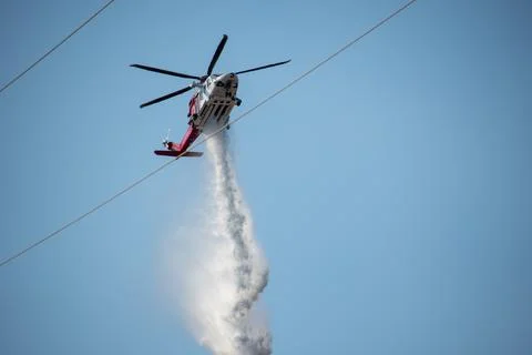A helicopter from the LAFD performs a water drop and observation during a bru Stock Photos