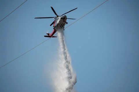 A helicopter from the LAFD performs a water drop and observation during a bru Foto stock