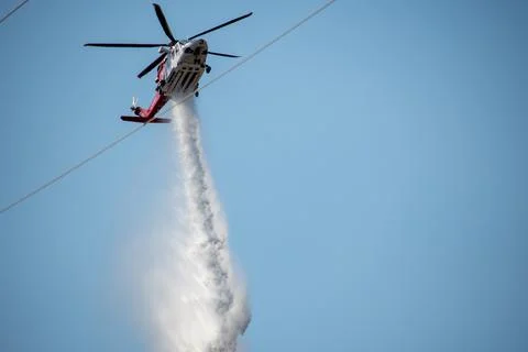 A helicopter from the LAFD performs a water drop and observation during a bru Foto stock