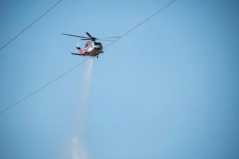 A helicopter from the LAFD performs a water drop and observation during a bru Foto stock